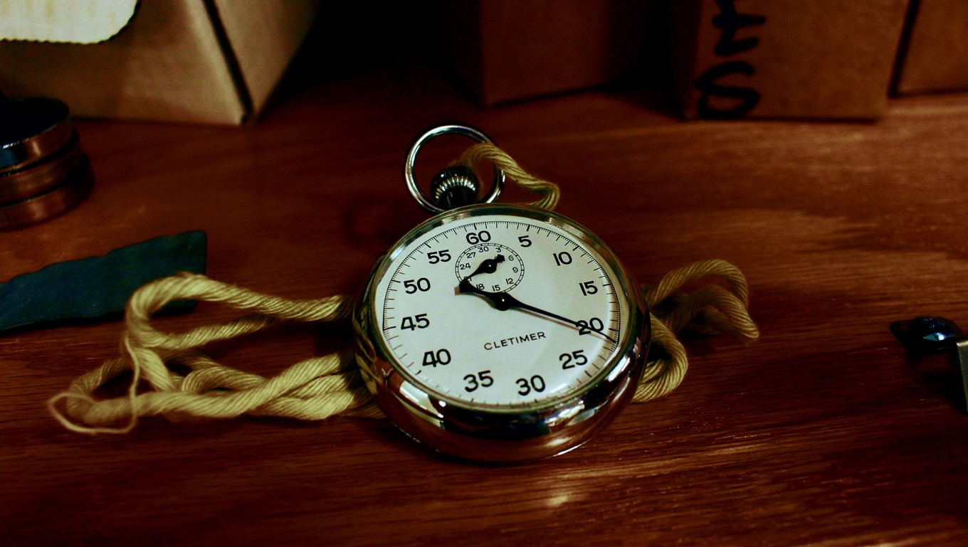 Gold stopwatch with chain on a timber table